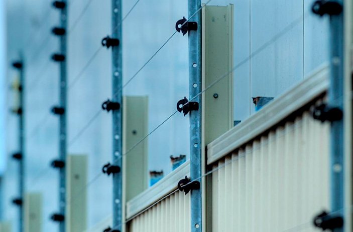 Sistema de cerca elétrica instalado sobre muro para reforço da segurança perimetral